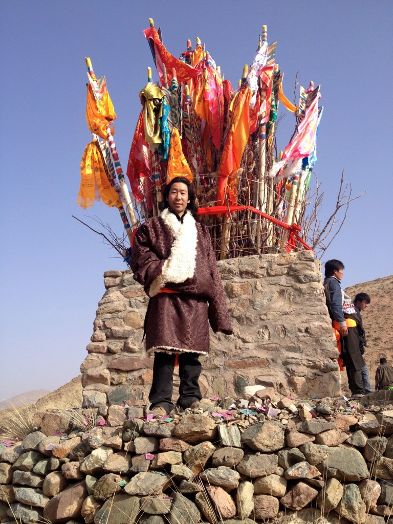 тибетец на фоне с лаци в деревне в Восточном Тибете